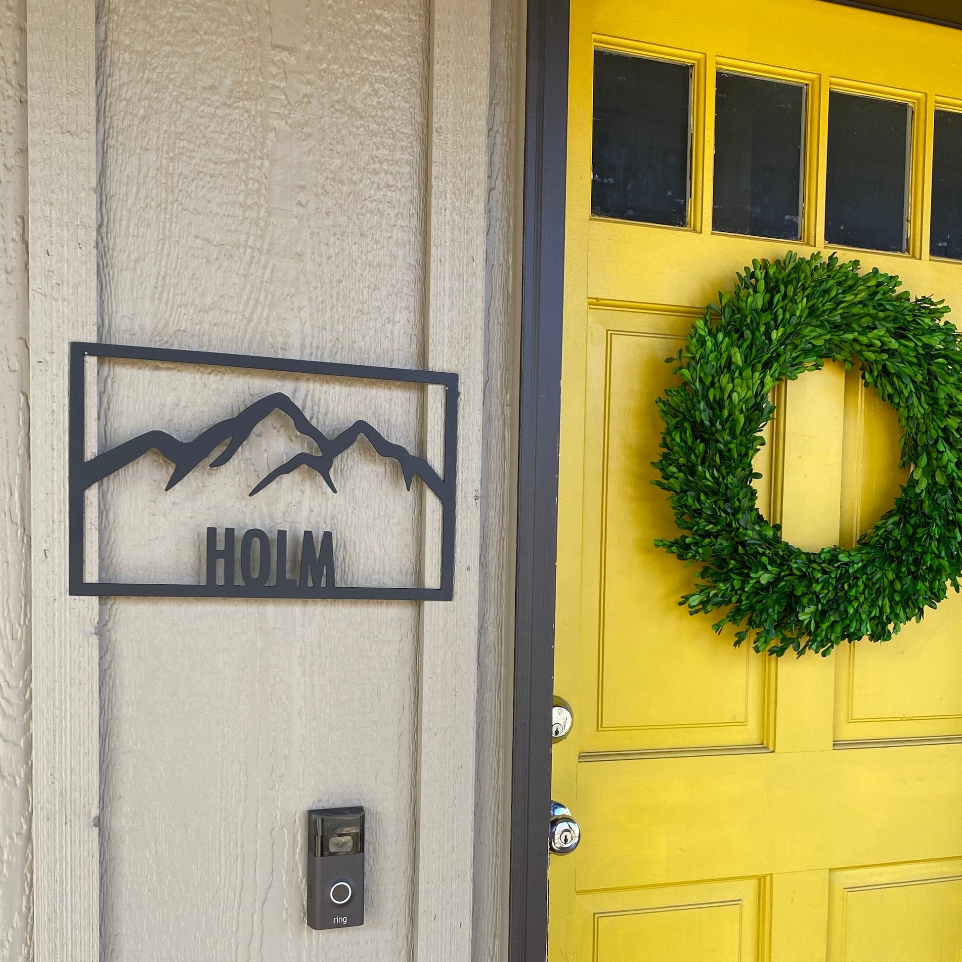 metal sign custom name - Holm with mountains mounted next to yellow door - by motomattick designs and LeeMo Designs in Bend Oregon