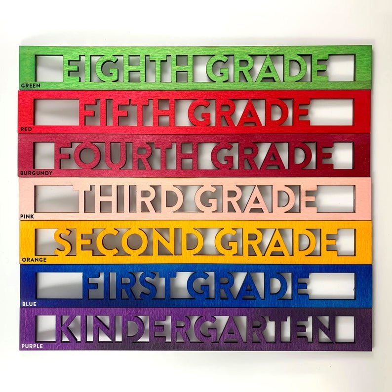 Reusable back-to-school wood sign - Laser cut grade inserts eighth grade in green, fifth grade in red, fourth grade in burgundy, third grade in pink, second grade in orange, first grade in blue, kindergarten in purple - By LeeMo Designs in Bend, Oregon
